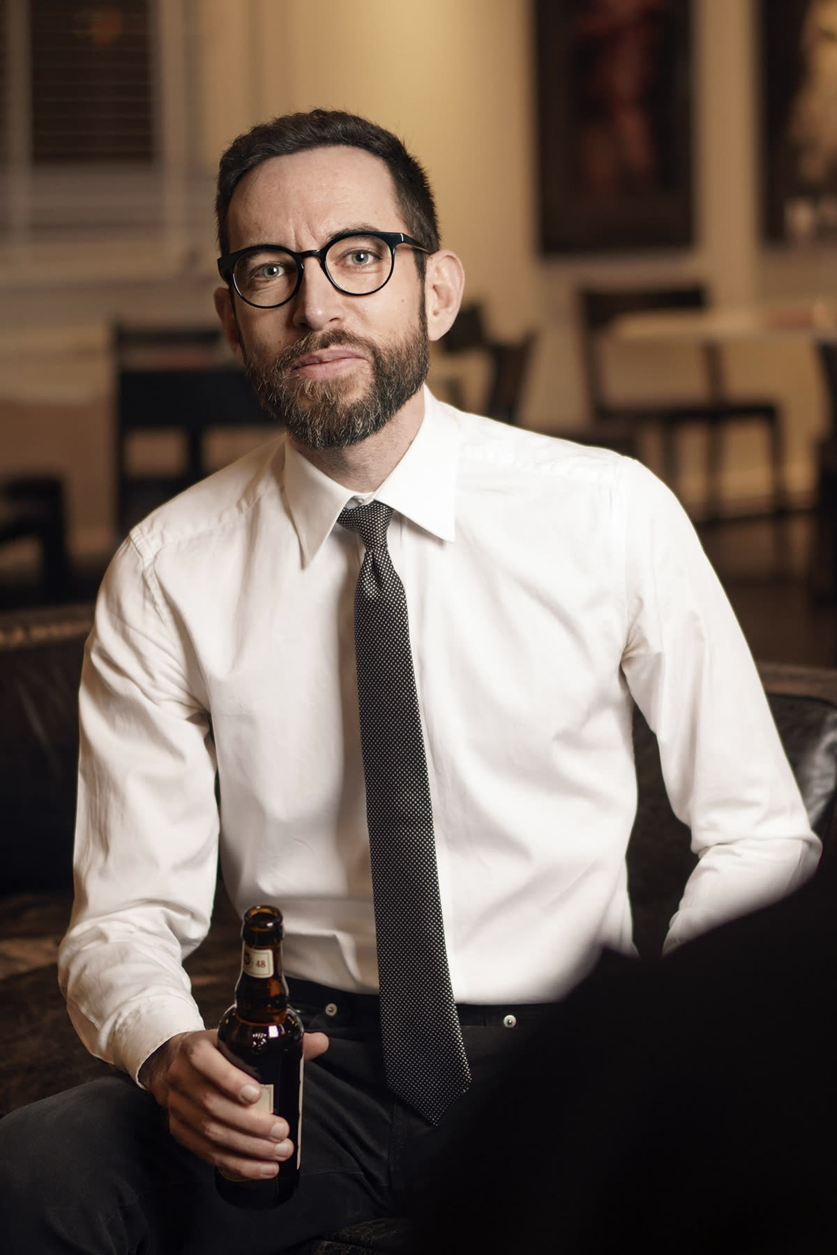 Tobias Runeson seated indoors wearing a white shirt and tie